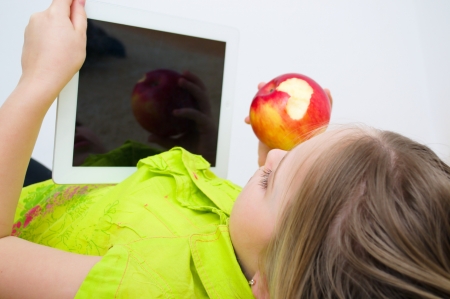 little girl watching tablet PC computer indoorsの写真素材