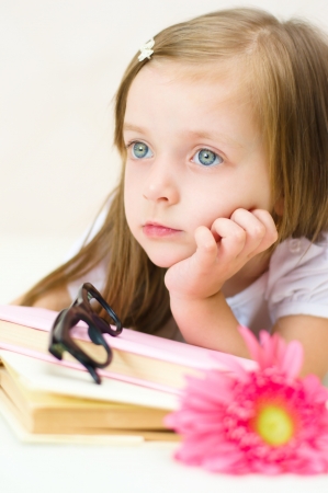 cute little girl reading indoorの写真素材