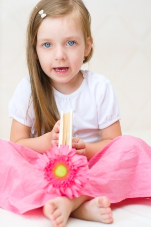 happy little girl plays with book indoorsの写真素材