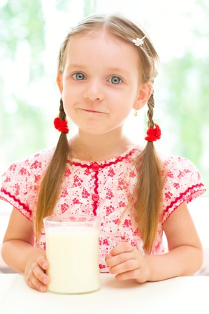 cute little girl with a glass of milkの写真素材