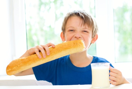 cute little boy with a glass of milk and long loafの写真素材