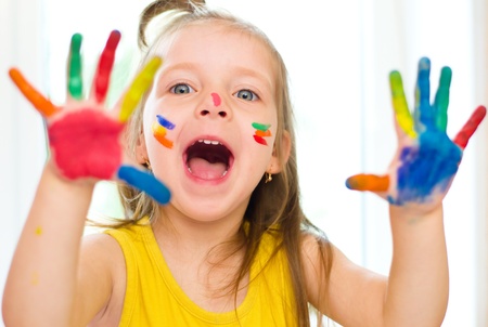 Cute little girl with painted hands indoorsの写真素材