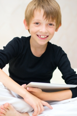 Happy little boy using tablet computerの写真素材