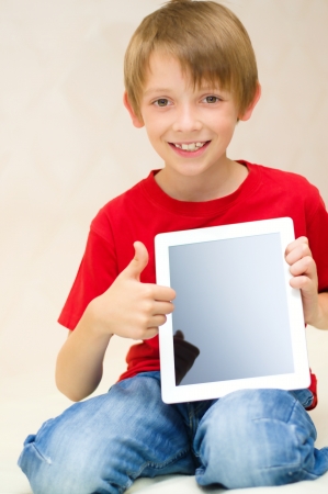Happy little boy with tablet computerの写真素材