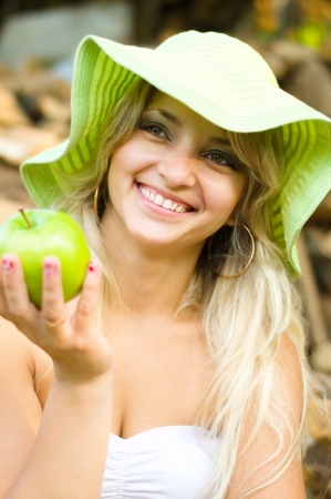 summer portrait of beautiful woman with green appleの写真素材