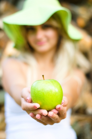 summer portrait of beautiful woman with green appleの写真素材