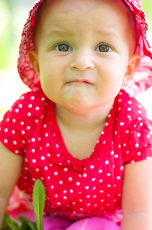 portrait of a cute baby sitting on the grass in park outdoorsの写真素材