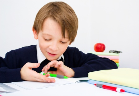 Little schoolboy writing homework from school in workbookの写真素材