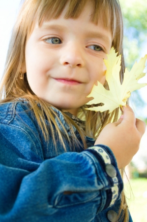 closeup autumn portrait of a little girl outdoorsの写真素材