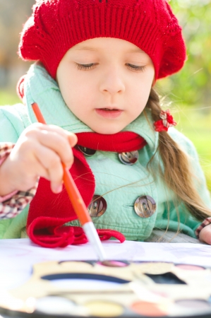 cute little girl is painting outdoorsの写真素材
