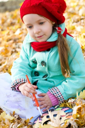 cute little girl is painting outdoorsの写真素材