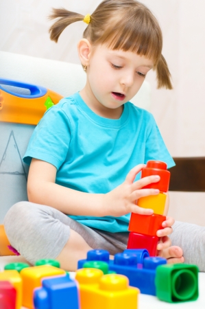 cute little girl playing with colorful building blocksの写真素材