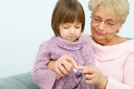 cute little girl and her granddaughter knitting togetherの写真素材