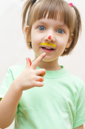 Portrait of a cute little girl with painted handsの写真素材