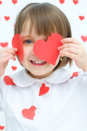 dreaming cute child holding red heartsの写真素材