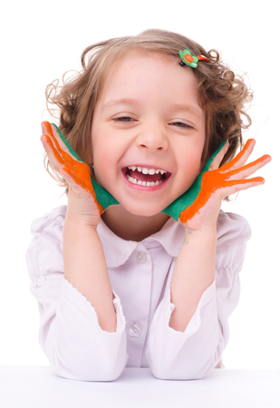 cute cheerful girl showing her hands painted in bright colors, isolated over whiteの写真素材
