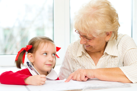Grandmother teaches to write letters her granddaughterの写真素材