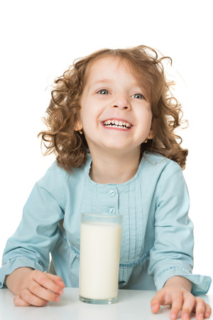 Portrait of a cute little girl drinks milk, isolated over whiteの写真素材