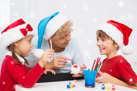 children with grandmother in santa hats preparing to Cristmasの写真素材