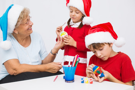 children with grandmother in santa hats preparing to Christmasの写真素材