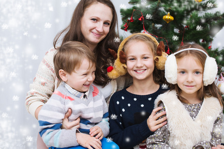 Christmas portrait of happy mother with children at homeの写真素材