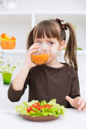 Little girl eating vegetable saladの写真素材