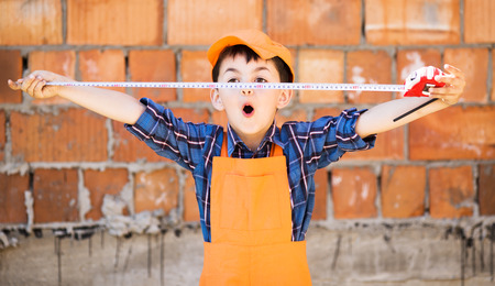 cute little builder  in hardhats with with measuring tape  working outdoorsの写真素材