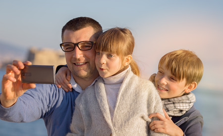 Father with his children  taking selfie outdoors