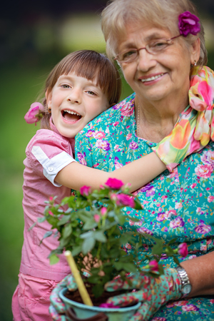 Happy Grandmother with her granddaughter working in the gardenの写真素材