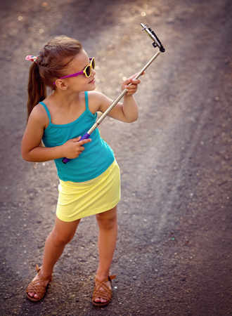 Cute little fashion girl taking selfieの写真素材