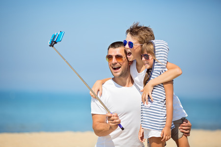 Father with children  taking selfie on the beach at the day time.の写真素材
