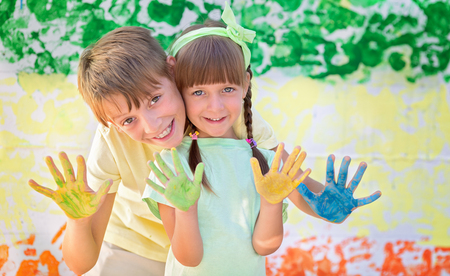 Playing with colors. Beautiful children with colorful hands, creative child conceptの写真素材