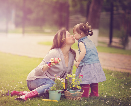Portrait of mother with daughter planting flowers into the flowerpot in the garden



の写真素材