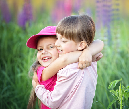 Cute little girls huggings outdoors. Friendship conceptの写真素材