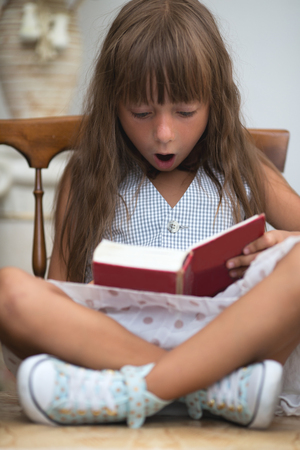 Cute little girl is reading bookの写真素材