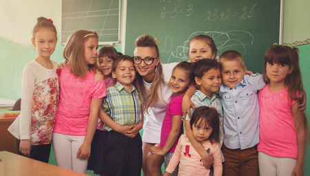 Lesson. Little schoolchildren are listening their teacher in classの写真素材