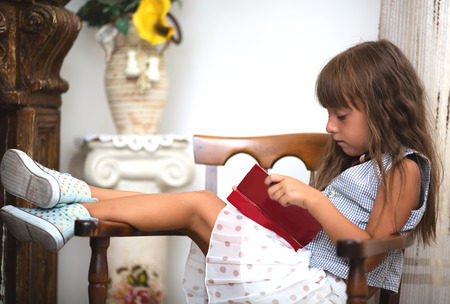 Cute little girl is reading bookの写真素材
