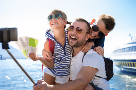 Summer holidays.Father with children are waiting summer sea vacationの写真素材