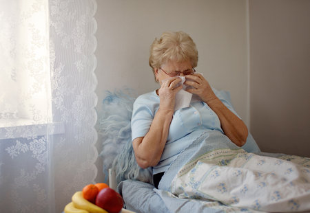 Sick Senior Woman.Flu.Woman Caught Cold. Sneezing into Tissue. Headache. Virus .Medicines. Elderly  Woman Infected With Cold Blowing Her Nose In Handkerchief. Sick woman with a headacheの写真素材