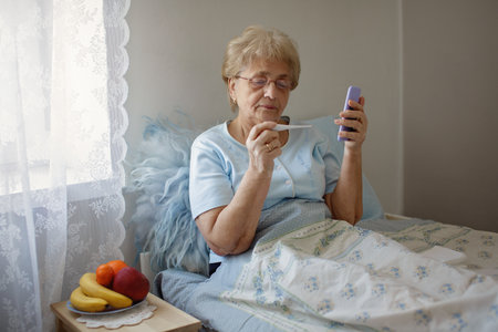 Healthcare and medical concept. Covid-19. Senior woman holding  thermometer and talking with doctor.  Virus Conceptの写真素材