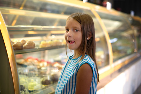 Food concept. Cute little girl is eating cakeの写真素材