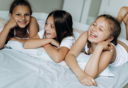Family and friends concept. Three sisters wake up and smiling in the morningの写真素材