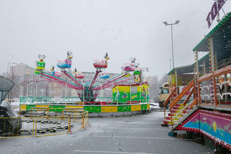 TALLINN, ESTONIA - APRILL 29, 2017: Empty snowy carousel during a sleet. Snow storm in the spring time.のeditorial素材
