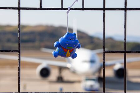Nagasaki, Japan - December 19, 2015. children's toy on a rope against the background of an airplane at the airport of Nagasaki (NGS), Omuraのeditorial素材