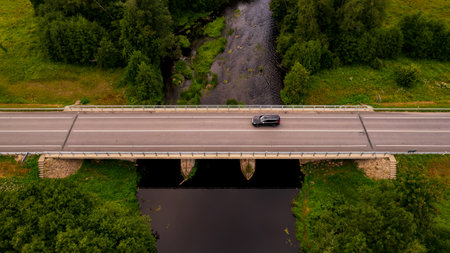 aerial view of a road bridge over a river. not big, beautiful, river in the countryside with a quiet...