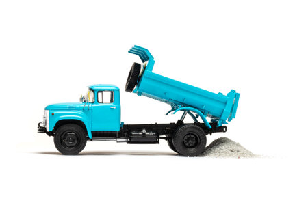 blue dump truck unloading sand isolated on white backgroundの写真素材