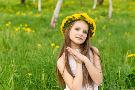 portrait of happy girl with wreath of flowers on nature in summerの写真素材