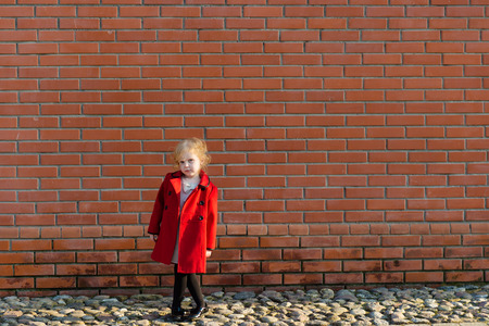 portrait of a cute little redhead girl in city at the wallの写真素材