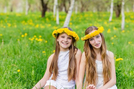 Portrait of happy children with wreath of flowers on nature in summerの写真素材