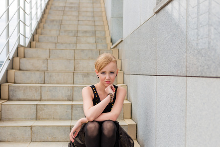 Portrait of a beautiful young girl on the stairsの写真素材